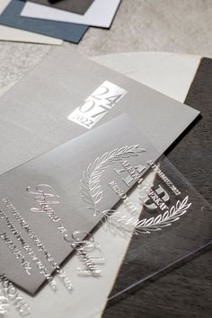 some silver and black business cards on a table