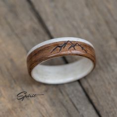 a wooden ring with mountains engraved on it