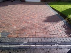 a red brick driveway in front of a house