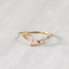 The Dove ring features clear and light blush pink marquise crystals in a V-shape, mixed with rose pink and lavender circle crystals. This dreamy ring adds the perfect colourful touch to your stacking look or outfit of the day. Main material: Rose Gold, Rhodium, 16k Gold Plated on Brass, Colourful Cubic Zirconia Need some jewelry inspiration? Follow us on Instagram  @statementGrey Dainty Pink Stackable Rings For Wedding, Delicate Cubic Zirconia Crystal Ring, Pink Dainty Birthstone Ring For Wedding, Pink Marquise Promise Ring, Pink Moonstone Promise Ring, Dainty Pink Crystal Ring For Wedding, Pink Adjustable Crystal Ring For Wedding, Pink Moonstone Wedding Ring, Feminine Adjustable Wedding Rings