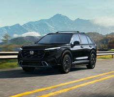 a black honda suv driving down the road