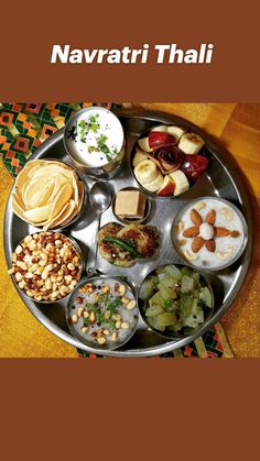 a metal tray filled with different types of food on top of a yellow table cloth