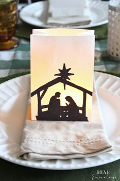 a nativity scene is displayed on a plate with napkins and place cards in front of it