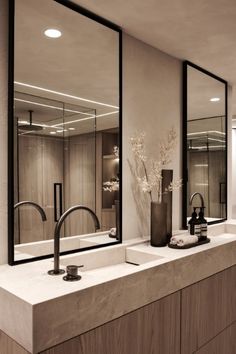 a bathroom with two sinks and mirrors in it