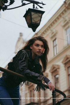 a woman leaning up against a lamp post