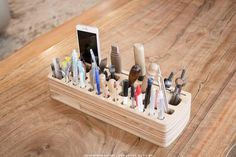 a cell phone is sitting on top of a wooden holder with toothbrushes and other items