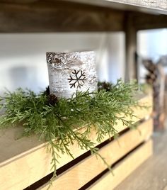 a candle is sitting on top of a window sill decorated with pine cones and greenery