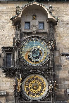 an ornate clock on the side of a building with sun and moon designs painted on it