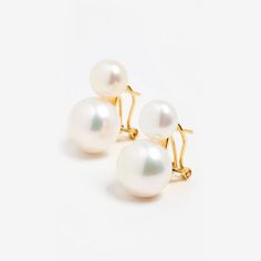 three pairs of white pearl earrings on a white background