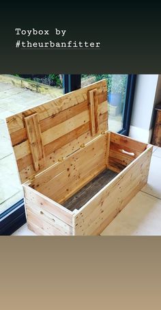 a wooden box sitting on top of a white floor next to a window with the words toybox by thurebatfitter