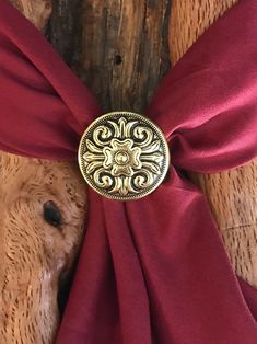 a close up of a red tie with a gold buckle on the back of it