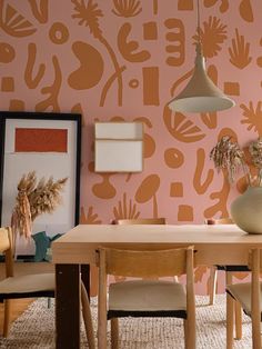 a dining room with pink wallpaper and chairs