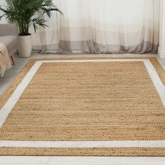 a living room area with a rug, chair and potted plant