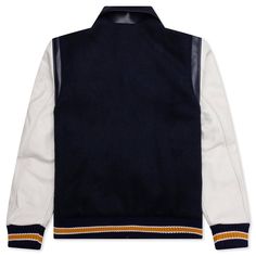 The BTFL Studios Letterman Jacket in Navy exemplifies the brand's commitment to blending heritage with modern design. Crafted from premium Japanese wool with Italian leather details, this jacket offers a luxurious take on the traditional American letterman style. It features a chenille embroidered patch, adding a touch of vintage charm. Each jacket is meticulously made, highlighting BTFL Studios' focus on quality and attention to detail. Premium Japanese wool Italian leather details Chenille emb Designer Winter Varsity Jacket For College, Luxury Varsity Jacket For College In Fall, Luxury Long Sleeve Varsity Jacket For College, Luxury Fall Varsity Jacket For College, Luxury Outerwear With Contrast Collar And Long Sleeves, Luxury Wool Outerwear With Ribbed Cuffs, Luxury Varsity Jacket For Streetwear In Winter, Luxury Varsity Jacket For Fall Streetwear, Luxury Streetwear Varsity Jacket With Padded Collar