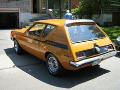 an orange car parked in front of a house