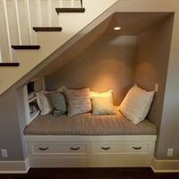 a room with some stairs and pillows on the bench in front of the bed area