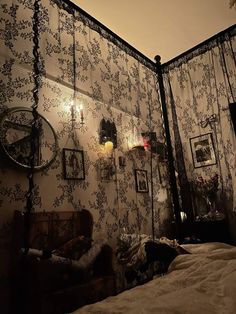 an old fashioned bedroom with floral wallpaper and lights on the headboard, along with antique furniture