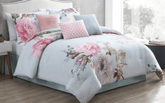 a bed with pink flowers on it in a bedroom