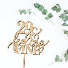 a wooden cake topper with the words'20 and feeling fine'on it