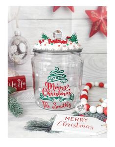 a glass jar filled with candy and christmas decorations