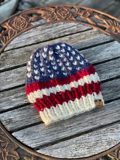 "Americana Beanie to show your patriotic spirit is perfect for this Red, White and Blue unisex hat! This Star Spangled hat will cover everything from Memorial Day to 4th of July and everything in between for those of us who just like showing our USA pride! Made to order has a quick turn around about a week! Beanie is made with a mix of acrylic and wool blend yarns in Lionbrand blue, fisherman and cranberry colors. Pattern by True North Knits, this wonderful hand knit hat is quite stretchy. 💙Adult size is a generous fit for ladies or men fitting from 21\"- 23\" circumference. This hat is trimmed with a leather logo tag stitched on. ❤️Toddler Size is suited for 1-3 year old , approximately 18-19\" circumference. Others sizes can be made. DM for questions! Recommend hand wash and lay flat to Crochet Red White And Blue Hat, Loom Knit Hat, Patriotic Hats, African Hats, Handmade Hats, Usa Pride, Loom Knit, Cranberry Color, Hand Knit Hat