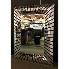 a mirror reflecting the inside of a room with chairs and desks in front of it