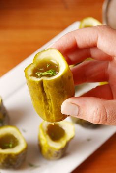 a person is holding an appetizer in front of some other food items on a plate