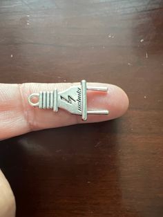 a finger with a tiny silver ring on it's thumb and an arrow in the middle