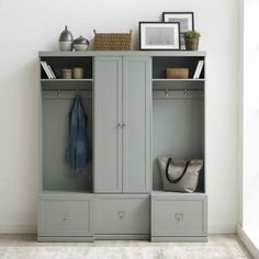 an empty room with a gray cabinet and coat rack