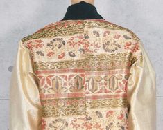 The jacket, which is casual in appearance yet glamorous and luxurious, is decorated with shiny gold leaf threads throughout, creating a noble presence. The abstract pattern of red and green gives the work a colorful and gorgeous appearance, and the ground pattern on the sleeves floats in gold, giving the work a sense of refinement down to the smallest detail. Dark green thick rib-knit fabric is used for the collar, cuffs, and hem, and lining is made of Meisen fabric.An adhesive core is used on t Luxury Long Sleeve Outerwear With Gold Embroidery, Fall Festive Outerwear With Gold Embroidery, Festive Fall Outerwear With Gold Embroidery, Winter Brocade Outerwear With Long Sleeves, Long Sleeve Brocade Outerwear For Winter, Fitted Gold Nehru Jacket For Winter, Luxury Long Sleeve Outerwear For Festive Occasions, Luxury Festive Long Sleeve Outerwear, Festive Gold Outerwear With Gold Embroidery