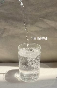 water being poured into a glass with the words stay hydrated above it and below