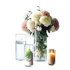 three vases filled with flowers and candles next to each other on a white surface