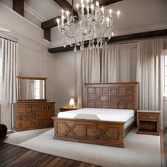 a bed room with a neatly made bed and a chandelier