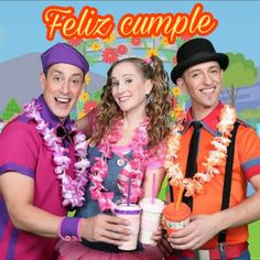 two men and a woman are dressed in colorful clothing, one is holding a drink