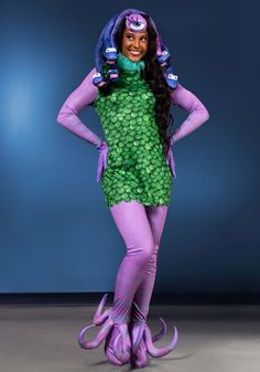 a woman in a green and purple costume posing for the camera with her hands on her hips