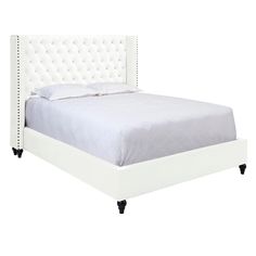 a white bed with tufted upholstered headboard and foot rests on wheels