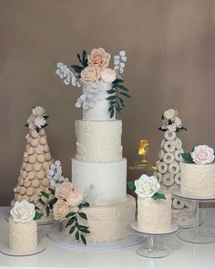 a table topped with three tiered cakes covered in white frosting and pink flowers