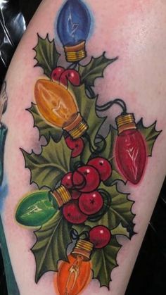 a tattoo with christmas lights and holly leaves on it