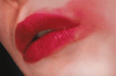 a woman's lips with red lipstick on the bottom half of her face and one eye open