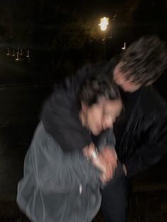 two people standing next to each other in the dark