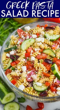 a bowl full of pasta salad with cucumbers and tomatoes