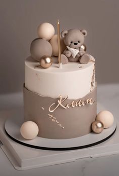 there is a cake that has a teddy bear on top and balls all around it