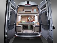 an open van door showing the bed area and storage compartment for a small camper