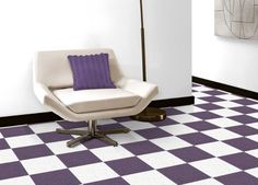 a white chair sitting on top of a checkered floor next to a purple pillow