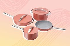 three pots and two pans on a pink background