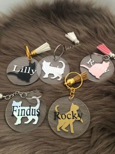 four keychains with different designs on them sitting next to a furry animal fur