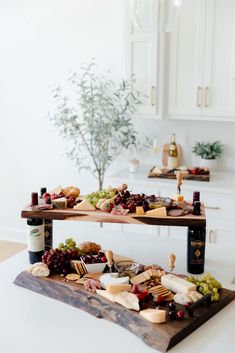 two tiered serving trays with cheese, meat and fruit on them in a kitchen