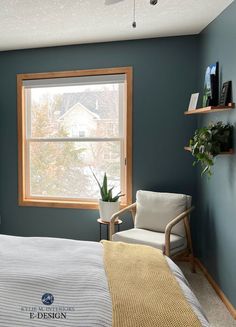 a bed room with a neatly made bed and a chair next to a large window