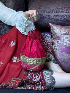 Festive Red Embroidered Bag, Embroidered Festival Pouch, Red Embroidered Shoulder Bag For Wedding, Festive Red Embroidered Pouch, Embroidered Pouch For Festivals, Red Bag With Zari Work For Festivals, Traditional Pink Shoulder Bag For Party, Festive Floral Embroidered Bag, Festive Pink Handcrafted Shoulder Bag