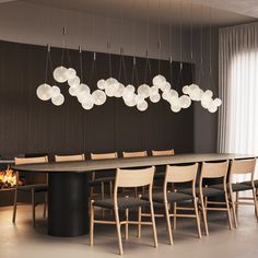 a dining room table with chairs and lights hanging from it's ceiling over the fire pit